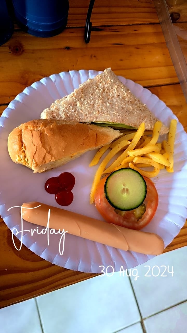 A plate of food on a wooden table with a sandwich, french fries, coleslaw, ketchup, and a hot dog, dated Friday 30 Aug 2024
